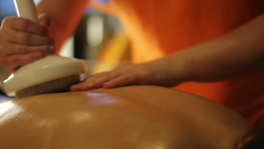 Masseuse performs stamp massage treatment