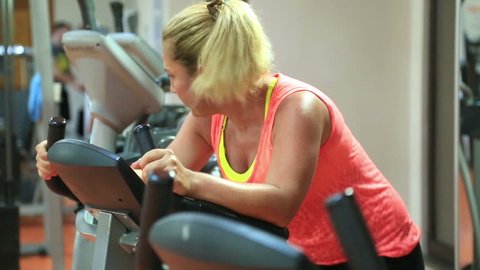 Woman Training On Exercise Bicycle In The Gym