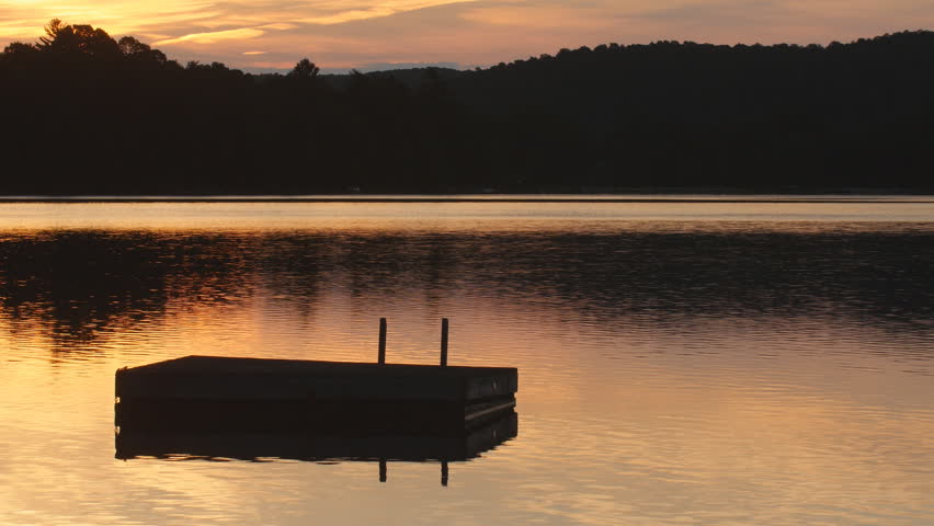 Sunrise morning at the lake with swimming platform. Cottage country. Eagle Lake, Ontario, Canada.
