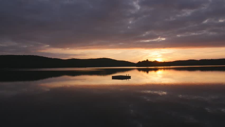 Dramatic sunrise with swimming platform. Eagle Lake, Haliburton, Canada.
