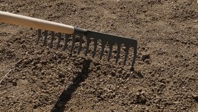 Slow motion using of weed raker for grading soil garden outdoor activities 1920X1080 HD footage - Wooden handle metal rake spreading and levelling ground slow-mo 1080p FullHD video