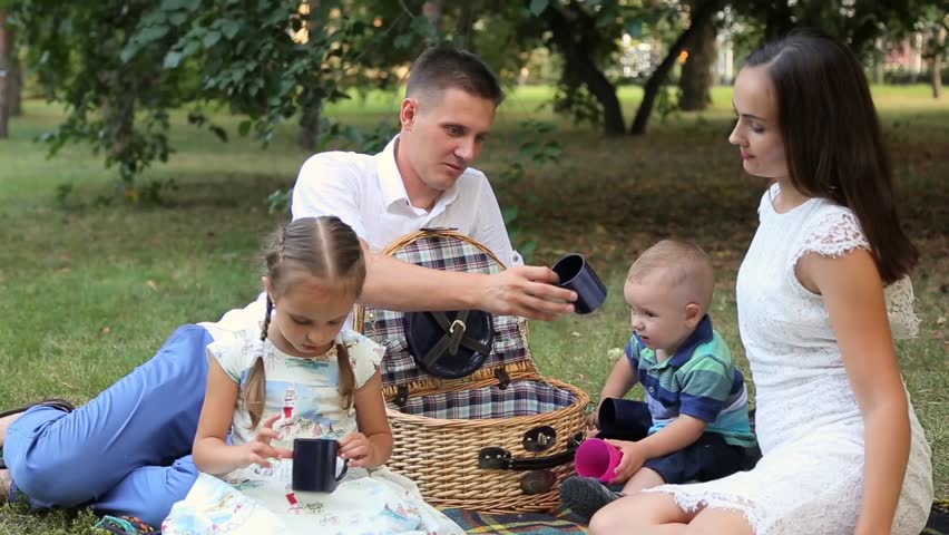 Young happy family of four on picnic in the park | Shutterstock HD Video #19787260