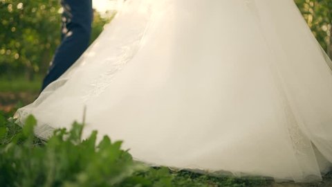 Feet of the bride and groom in the green grass