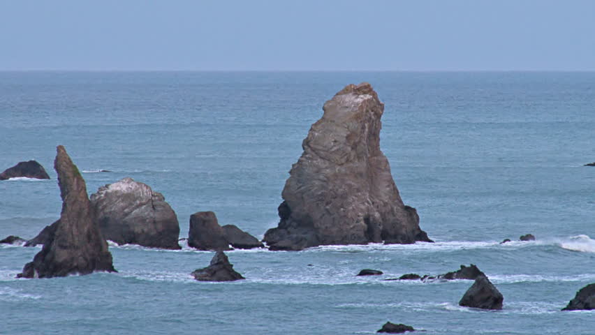 Sea stacks, monuments of past geologic events, protrude from the Pacific ocean