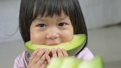 4K : Lovely Asian child girl eating delicious green melon