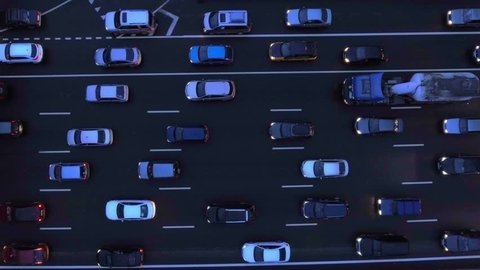 Aerial, flight over slow flow of cars in traffic jam on highway at night.