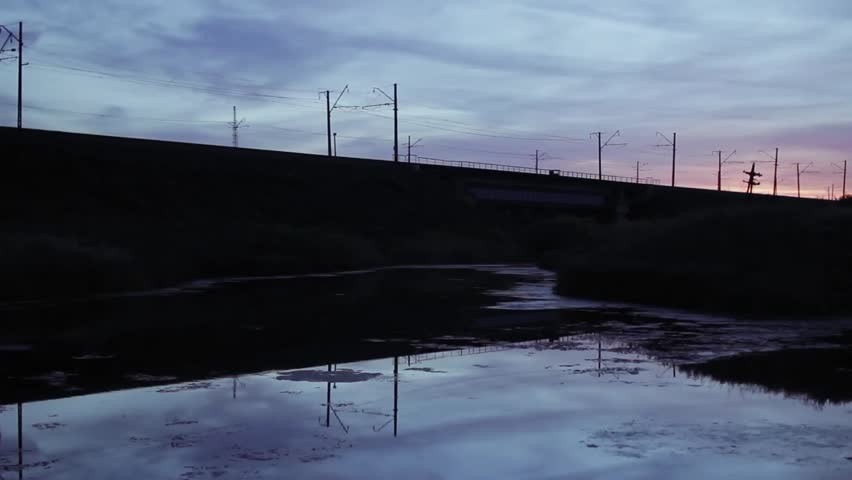 Freight Train Passes Over The Railway Bridge, Silhouette Of Train Crossing Bridge