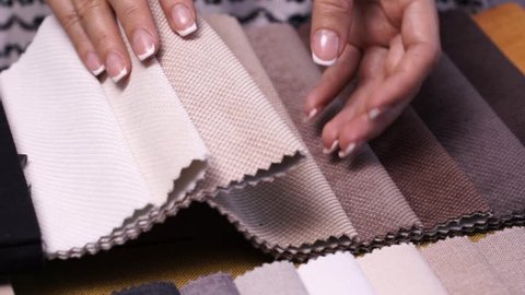 Female hands choosing fabric stitched upholstery