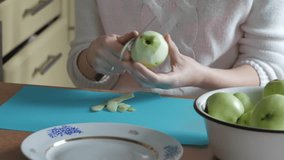 A woman peeled an apple on a plate. Part 1. Woman clears the table.