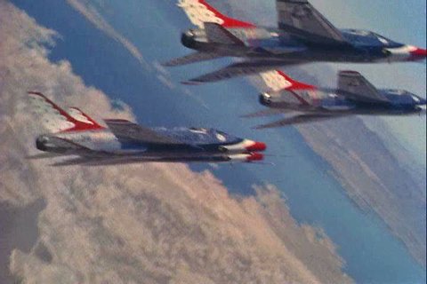 Supersonic jets fly in formation over water and mountainous terrain in 1959 (overhead shots). (1950s)