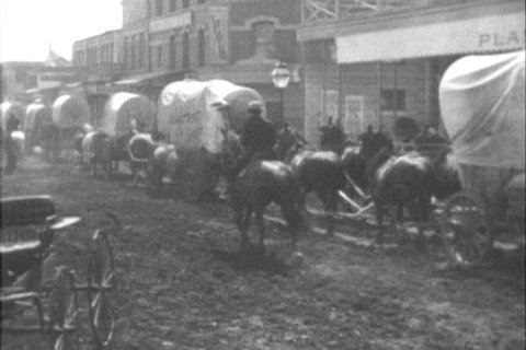 Wagon trains depart from St. Louis in the 1800s (as depicted in 1954). (1950s)