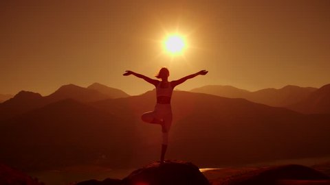 4K yoga in the mountains,the sunrise, a beautiful girl dressed in white ,pulls his hands to the sun