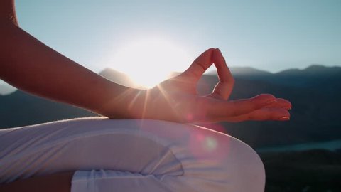4K beautiful girl in white clothes doing yoga in the mountains,sunrise,sun glare, close-up