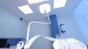 Dentist and his assistant leaning over a patient sitting in the chair, camera point of view