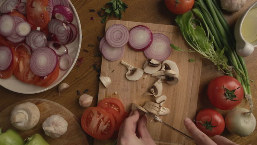 Female hands cut champignon mushroom POV
