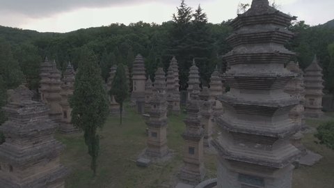 Slow aerial flight over an intimate pagoda forest, serving as a cemetery at the grounds of the Shaolin temple in Henan, China. 