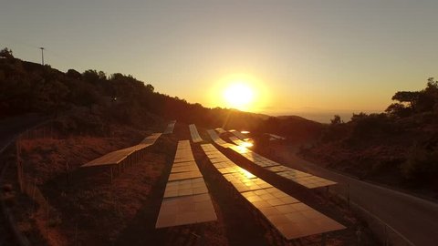 Solar Park AERIAL in the sunset. 4K Video footage of power generation with solar cells in southern europe (Greece)