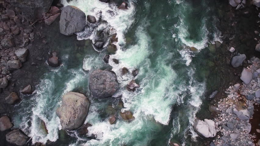 Overhead Aerial of Raging River with White Water Rapids and Rock Boulders