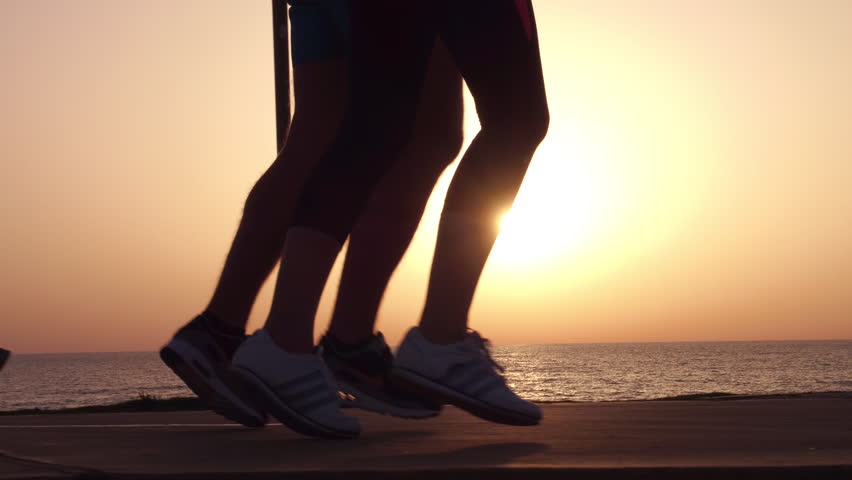 Running sport athletes woman and man jogging at night sunset.