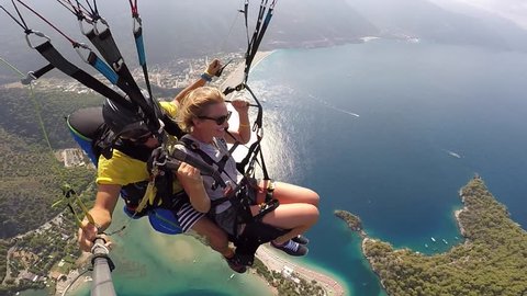 Tandem paragliding. Fear and joy. Extreme touristic Attraction. Paragliders flies over sea coast