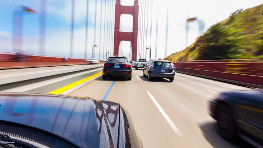 First person hyperlapse point of view, outside car, bonnet perspective crossing the Golden Gate Bridge from Marin into San Francisco driving thru traffic on a blue sky day. 4k 30fps time-lapse