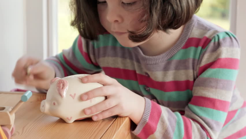 Little girl saving pound coins