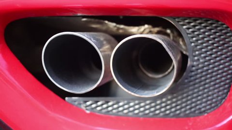 MOSCOW, RUSSIA - JUNE 22, 2016: Exhaust pipe of red Ferrari produces smoke