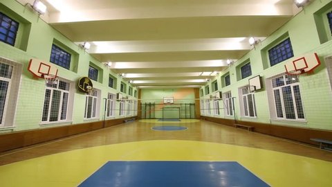 The light turns off in an empty spacious sports hall for basketball
