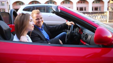 MOSCOW, RUSSIA - JUNE 22, 2016: Man and woman sitting in a red Ferrari and drive away