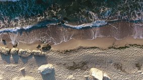     Aerial view of wave, sea and sandy beach. Perspective is straight down. 