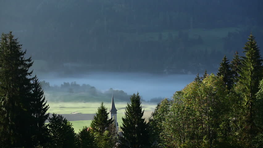 Morning fog in swizerland and a church tower