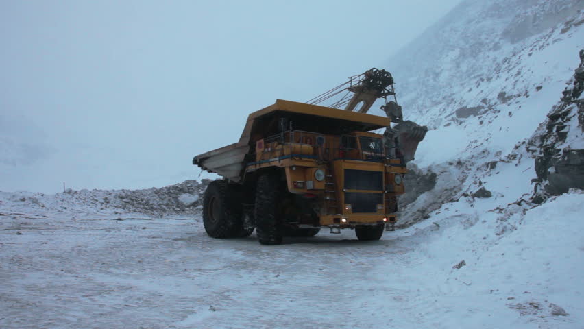 Dump truck loaded with an excavator bucket