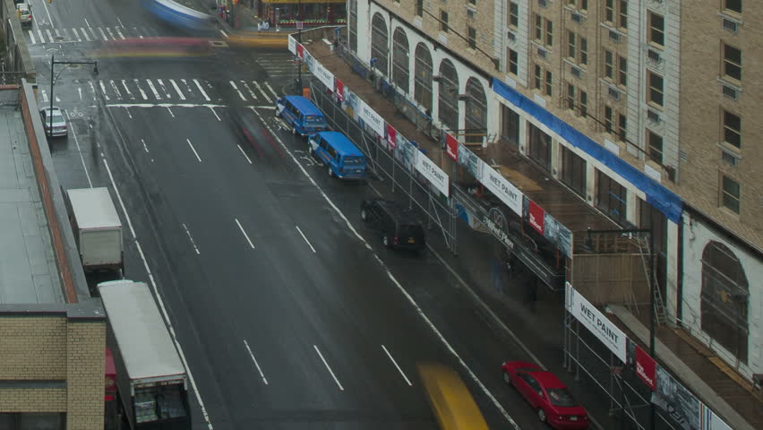 NEW YORK CITY - FEB 11: Timelapse of traffic on a wet street passing by on 8th
