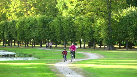 A mother and her son cycling through a park in Stockholm, Sweden