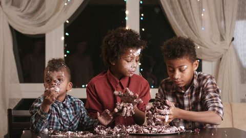 Children smeared in cake. Boys are eating dessert. Tell me the recipe. Three hungry brothers.
