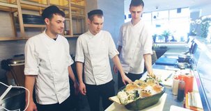 4k video shooting: three professional chefs prepare sushi set in a restaurant kitchen.