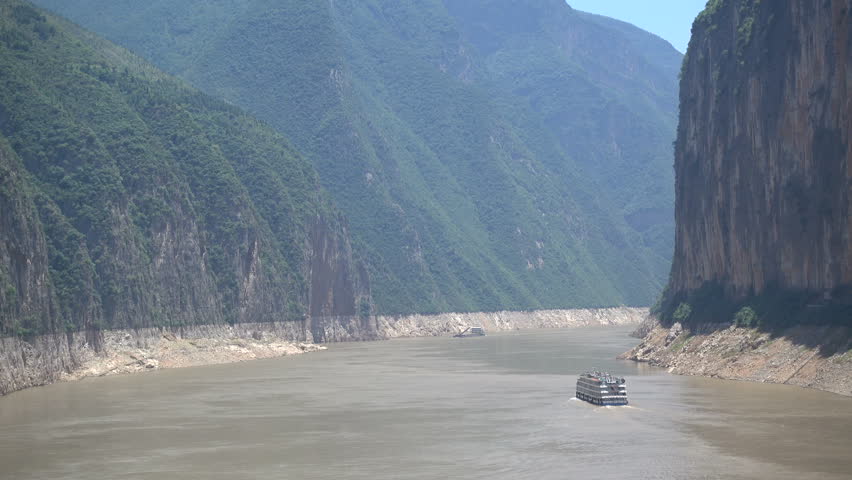 A ferry sails through the mighty cliffs of the Qutang gorge, one of the famous Three Gorges along the Yangtze river in China