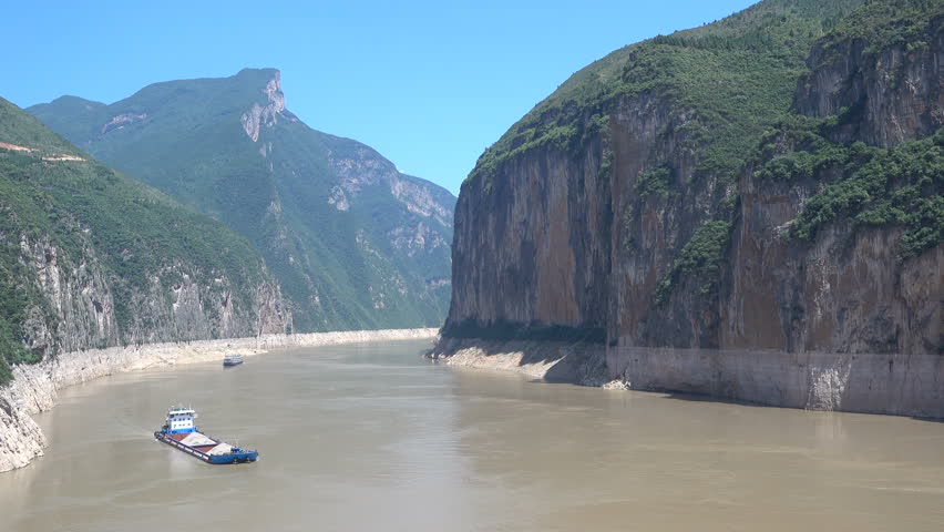 A cargo vessel sails through the impressive Qutang gorge on the Yangtze river, waterway transport in China
