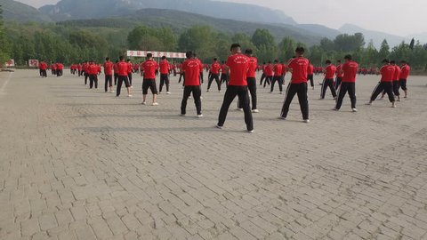 SHAOLIN, CHINA - MAY 2016: Groups of kung fu martial arts students practice at the training grounds of a large institute in Wushu, the 'birthplace' of kung fu in central China
