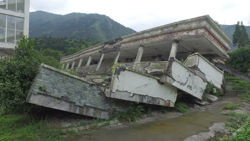 Walking past collapsed buildings of a school at the Wenchuan earthquake memorial in Sichuan province, China
