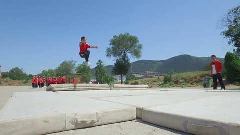 SHAOLIN, CHINA - MAY 2016: Young kung fu students make backflips at a martial arts institute in Shaolin, the 'birthplace' of kung fu, in central China