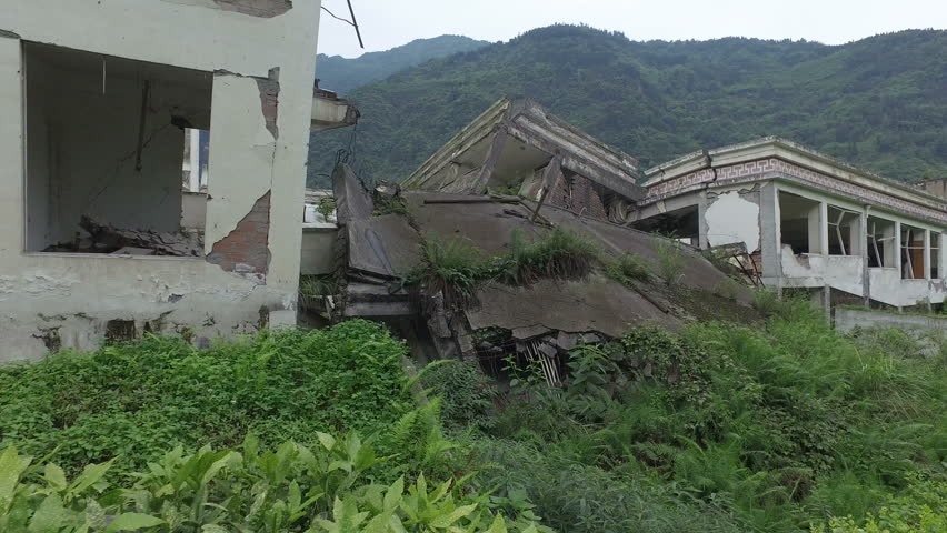 Walking past collapsed buildings of a school at the Wenchuan earthquake memorial in Sichuan province, China
