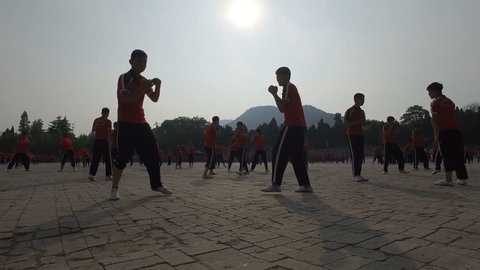 SHAOLIN, CHINA - MAY 2016: Silhouettes of martial arts students boxing (as part of a training session) at the grounds of the Shaolin Kung Fu institute in central China
