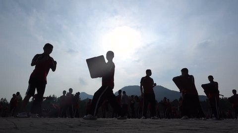 Slow motion of martial arts students practicing boxing skills at the playground of a major kung fu institute in Shaolin, the 'birthplace of kung fu', in central China
