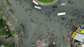 Aerial city view, flying over a city, a suggestive perpendicular aerial video above a traffic roundabout with a lot of traffic
