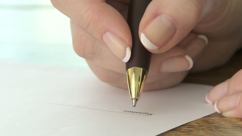 Woman signing signature with a ballpoint pen