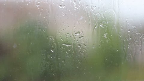 Rain and water drops falling on glass during rain storm, close up. 1920x1080 and 25fps