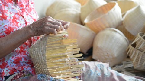 Woman weaving a basket of bamboo. Crafts in Thailand.