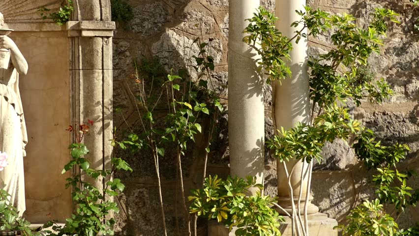 Statue of a woman with a cup. Church of Saint Bartholomew facing the east side of Placa is flanked by ajuntament and Banco de Soller. Soller, Mallorca, Spain.