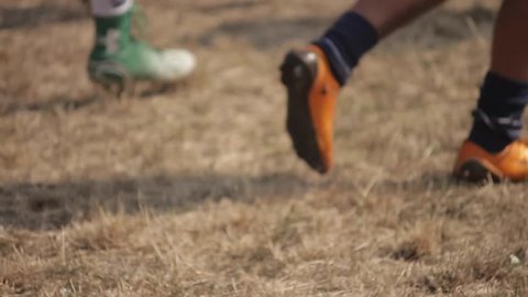 American football training. Men running on a football field. Legs and sportswear. Close-up.